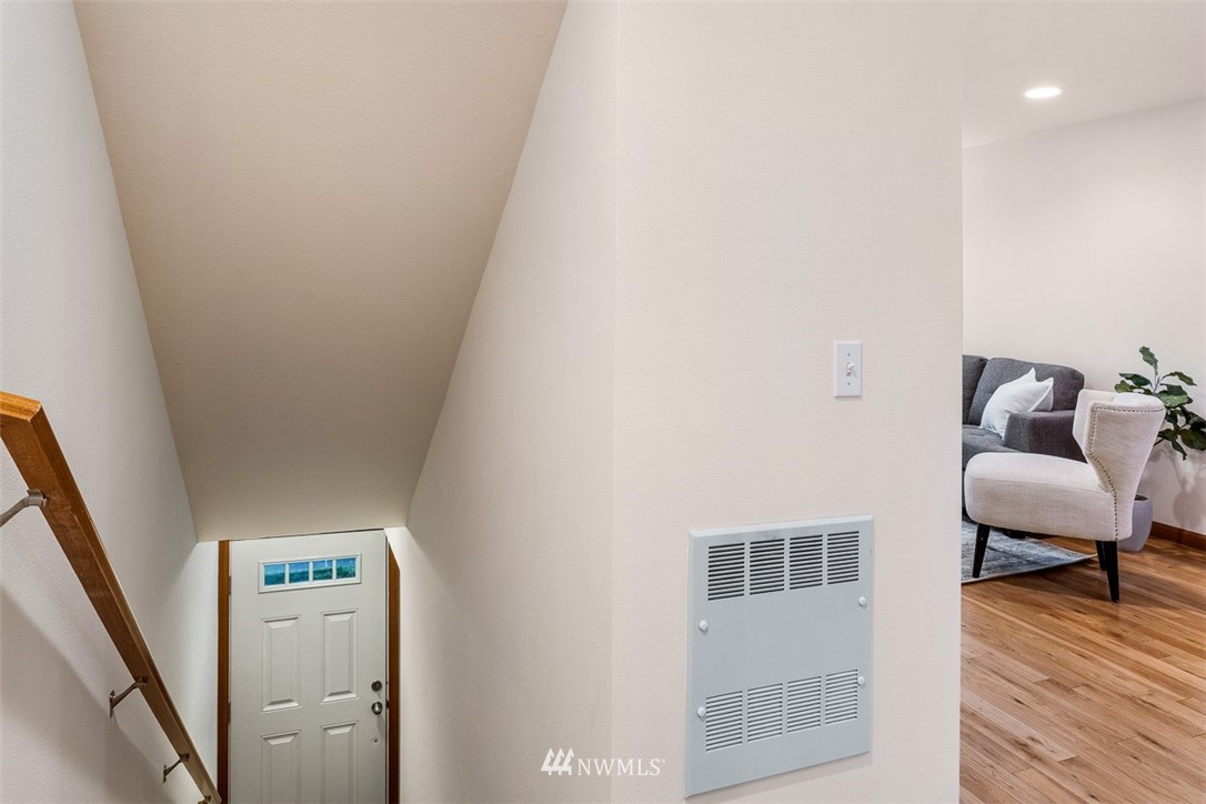 1122 North 92nd Street, Unit B Seattle, WA 98103 - Photo 5 of 32 a hallway with a couch and wooden floor