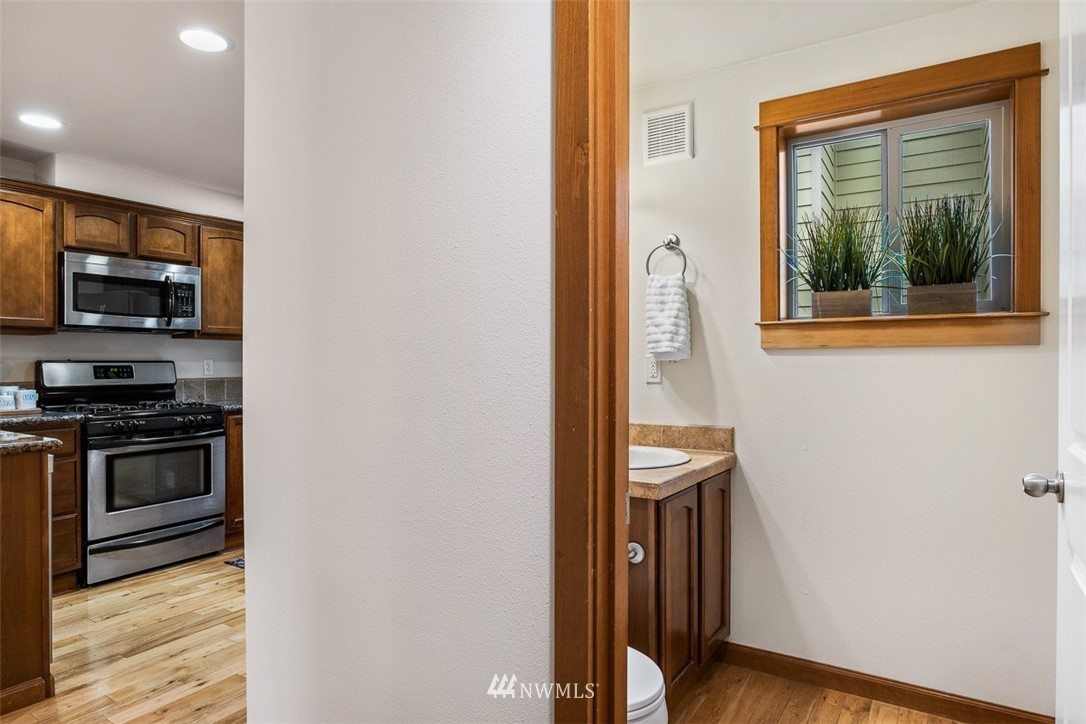 1122 North 92nd Street, Unit B Seattle, WA 98103 - Photo 6 of 32 a kitchen with a refrigerator and a stove top oven