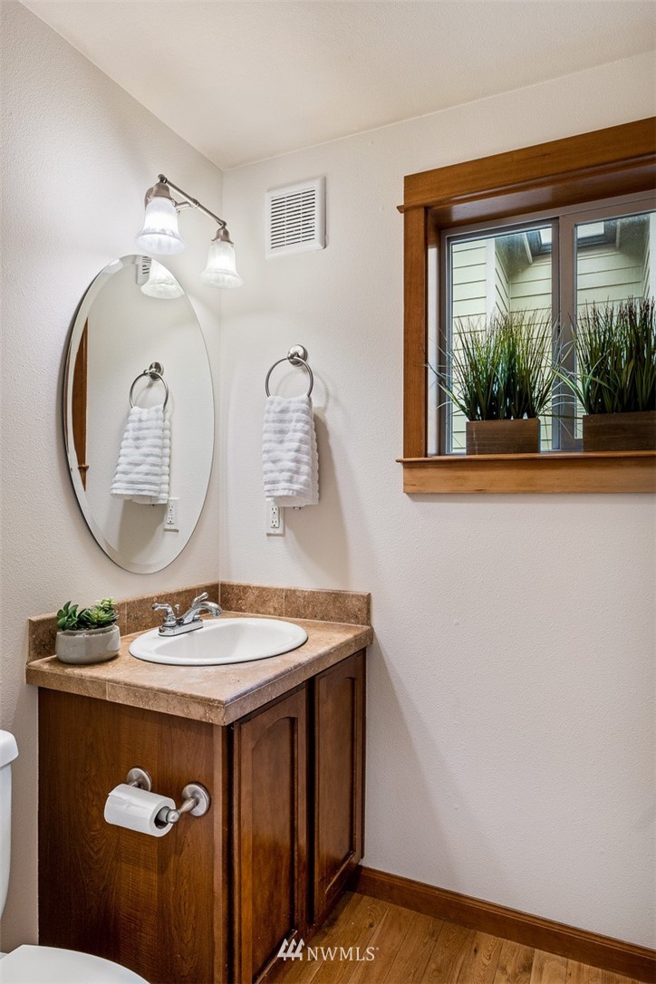 1122 North 92nd Street, Unit B Seattle, WA 98103 - Photo 7 of 32 a bathroom with a sink a mirror and a window