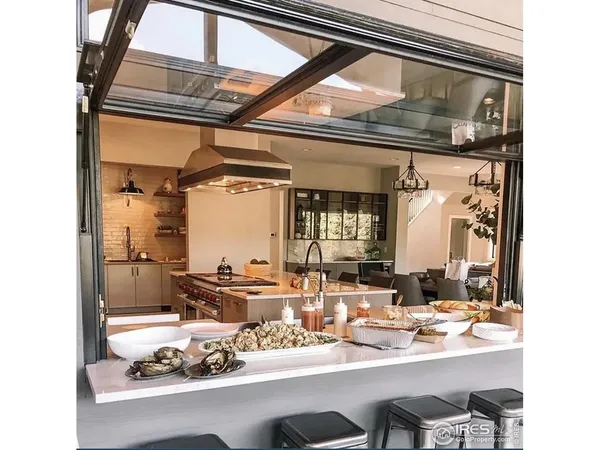 a kitchen with stainless steel appliances granite countertop a refrigerator a oven a sink and white cabinets with wooden floor