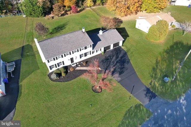 an aerial view of a house with a garden and lake view