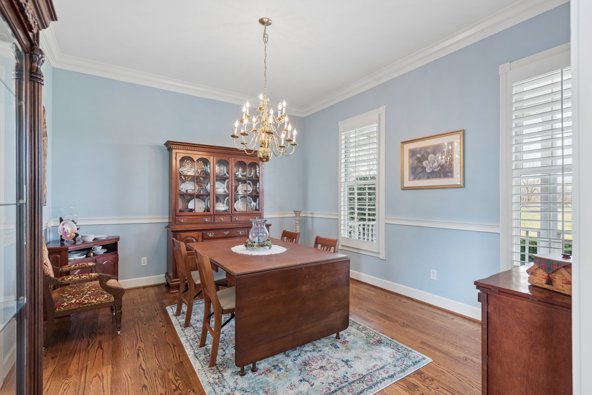 255 Lindsey Hollow Road Gallatin, TN 37066 - Photo 18 of 40 a dining room with wooden floor a chandelier a wooden table and chairs
