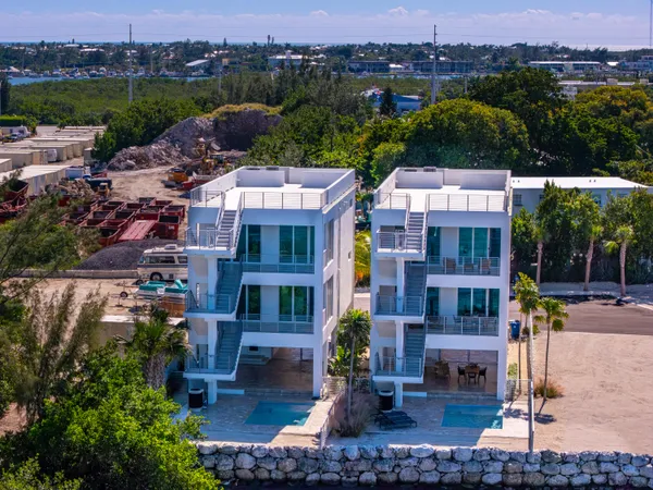an aerial view of multiple houses with a yard