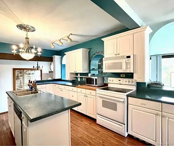 a kitchen with a stove and white cabinets