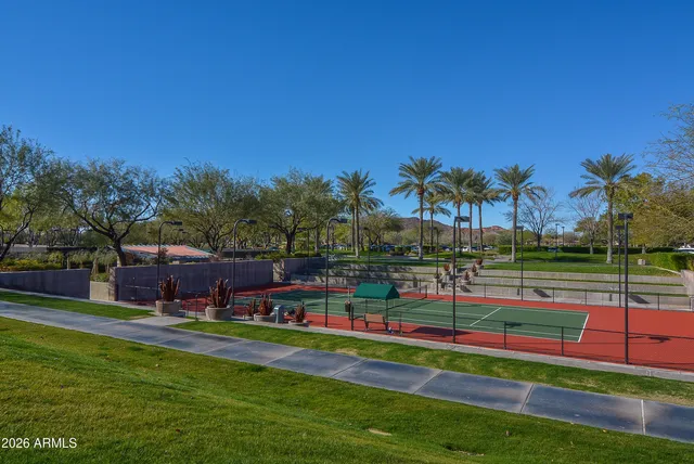 a tennis court with view of trees in the background