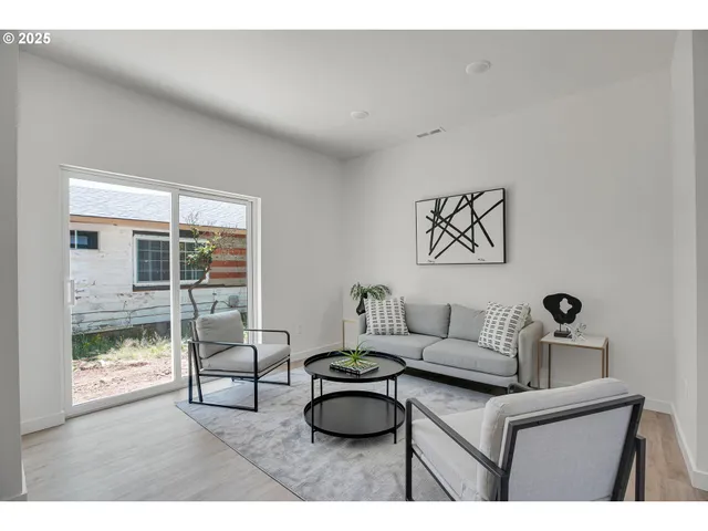a living room with furniture and a floor to ceiling window