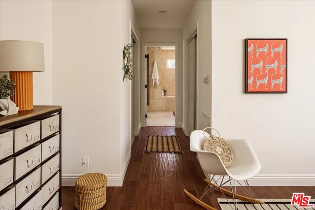 a view of a hallway with wooden floor and furniture