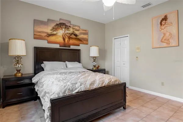 a bedroom with a bed and a lamp on dresser