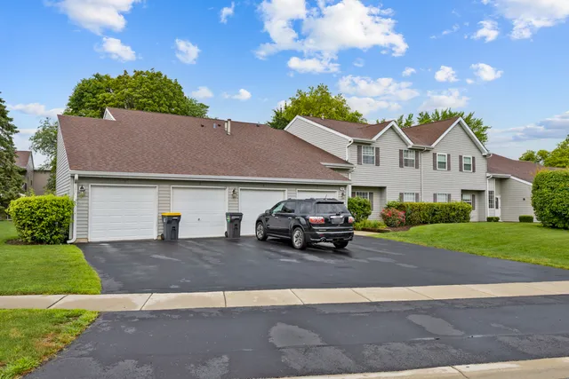 a car parked in front of a house next to a yard