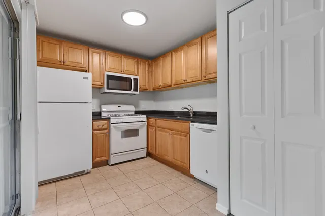 a kitchen with white cabinets and white appliances