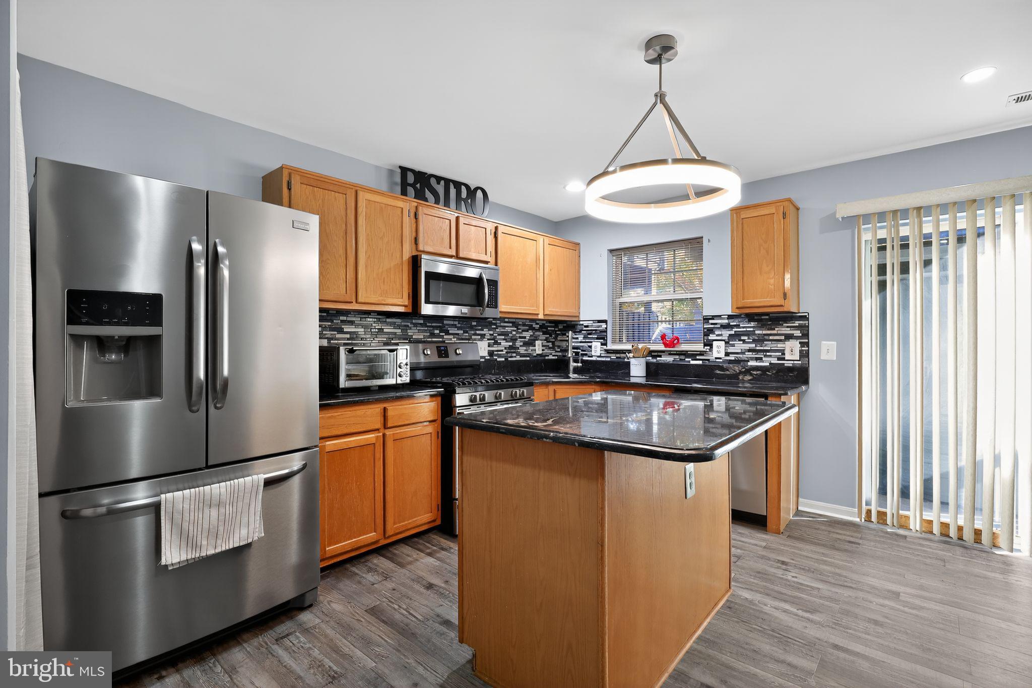 45481 Bluemont Junction Square Sterling, VA 20164 - Photo 5 of 30 a kitchen with stainless steel appliances granite countertop a refrigerator a stove a sink and a microwave