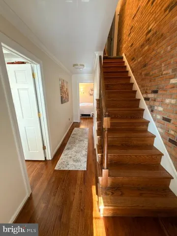 a view of entryway and hall with wooden floor