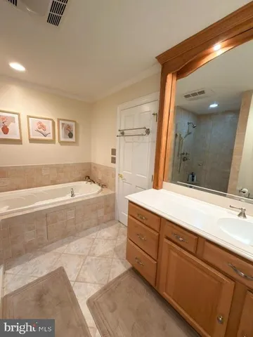 a spacious bathroom with a tub sink and mirror