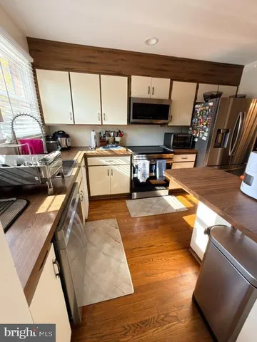 a kitchen with stainless steel appliances a stove a sink and a refrigerator
