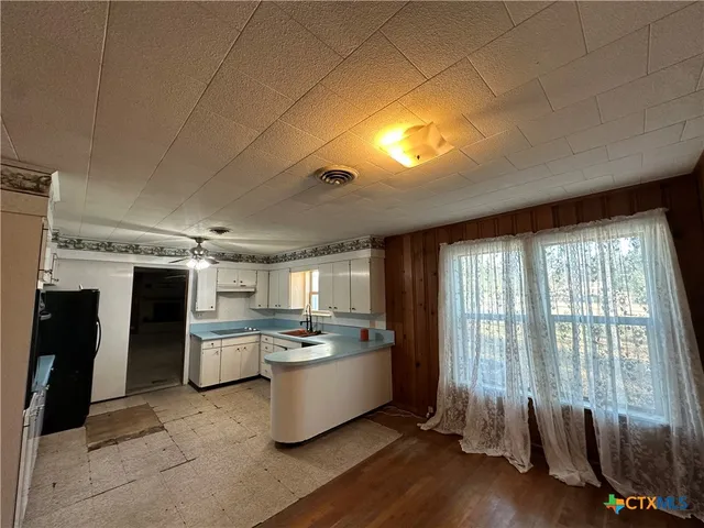 a bathroom with a granite countertop sink a mirror and shower