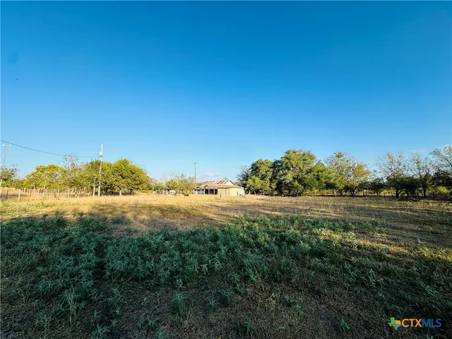a large white kitchen with wooden floor and stainless steel appliances