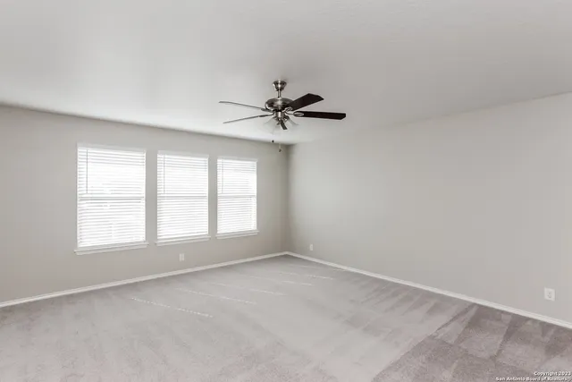 an empty room with a window and a fan