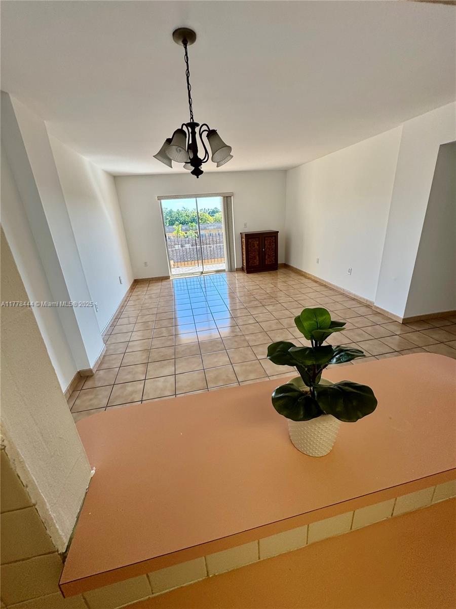 a living room with stainless steel appliances furniture a rug and a counter top