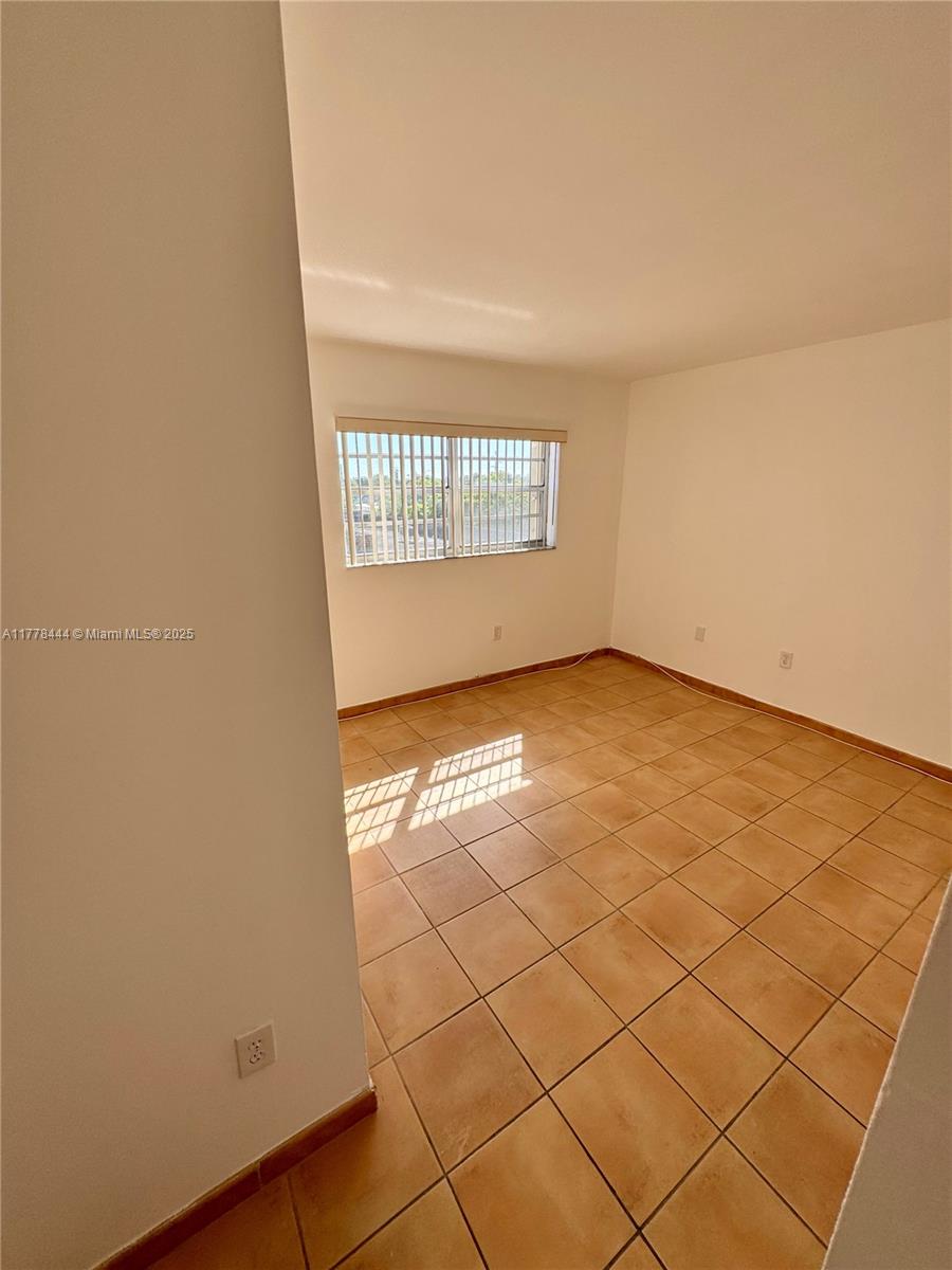 1075 West 68th Street, Unit 314 Hialeah, FL 33014 - Photo 20 of 27 an empty room with windows