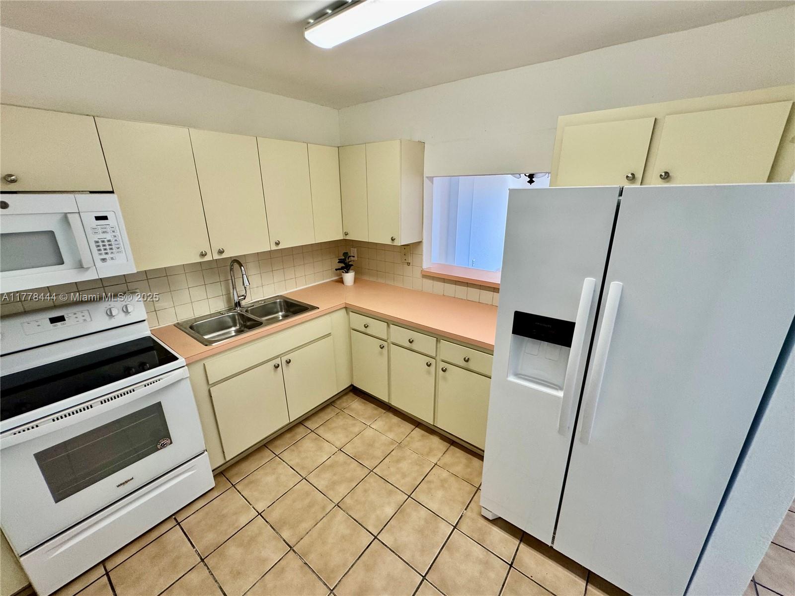 1075 West 68th Street, Unit 314 Hialeah, FL 33014 - Photo 4 of 27 a kitchen with a sink cabinets and appliances