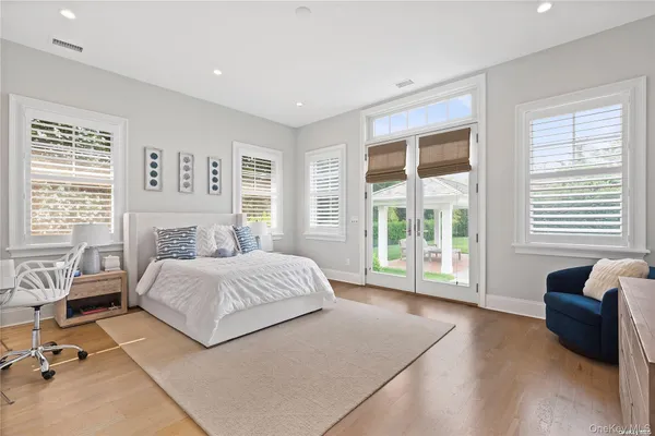 a spacious bedroom with a bed and glass window