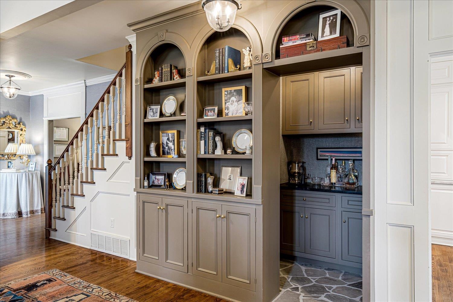 485 River Ridge Cove Memphis, TN 38120 - Photo 10 of 33 Bar featuring dark wood-style flooring, open shelves, crown molding, suspended lighting, and herringbone fabric walls.