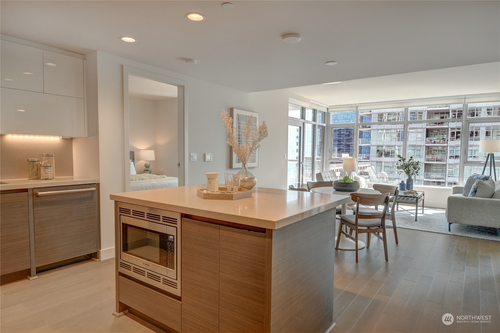 583 Battery Street, Unit 1601N Seattle, WA 98121 - Photo 5 of 27 a kitchen with kitchen island a stove a table and chairs