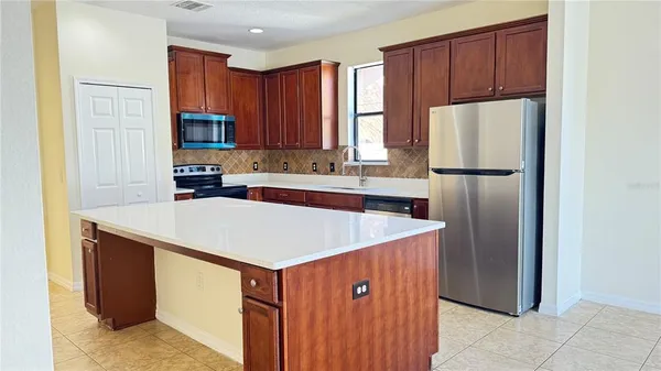 a kitchen with a refrigerator a sink a stove and cabinets