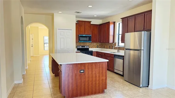 a kitchen with a refrigerator a sink and cabinets