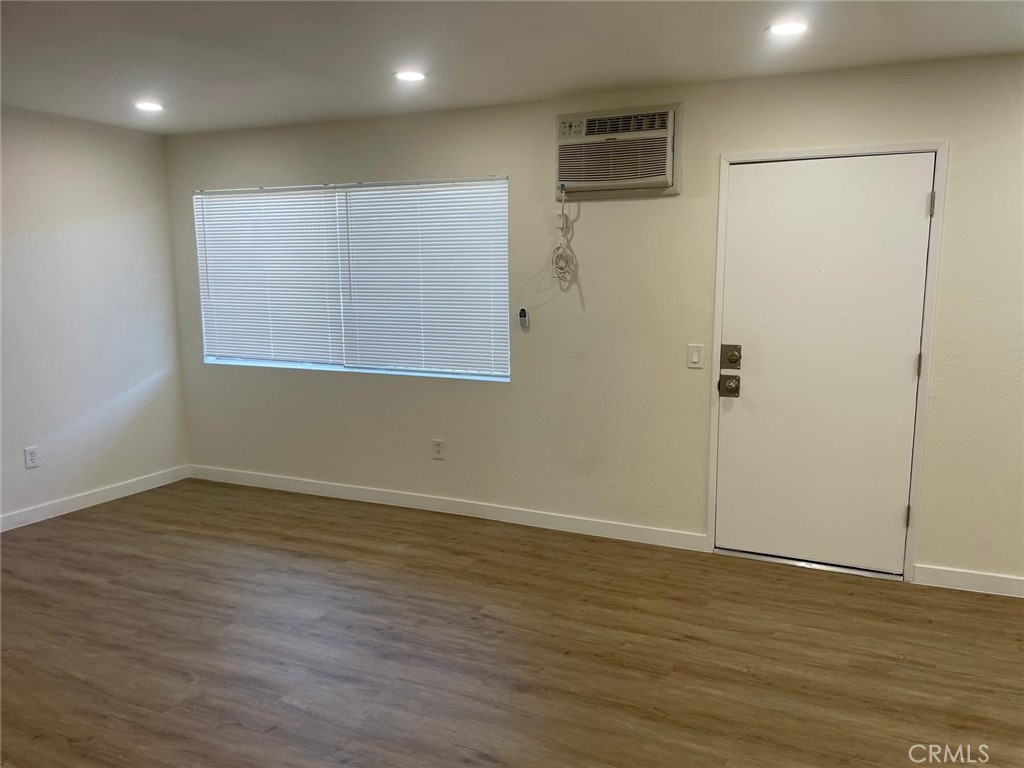 8135 Reseda Boulevard, Unit 9 Reseda, CA 91335 - Photo 1 of 8 an empty room with wooden floor and a window