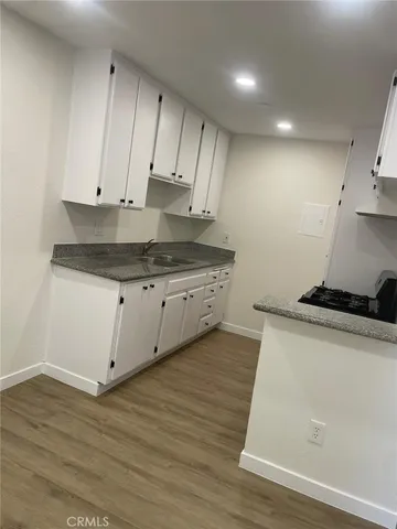 a kitchen with granite countertop wooden cabinets and white appliances