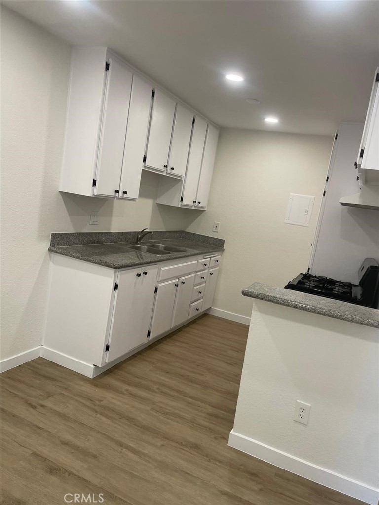 8135 Reseda Boulevard, Unit 9 Reseda, CA 91335 - Photo 2 of 8 a kitchen with granite countertop wooden cabinets and white appliances