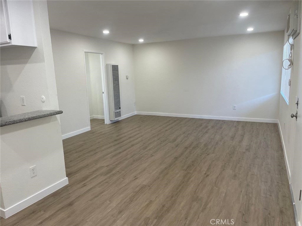 8135 Reseda Boulevard, Unit 9 Reseda, CA 91335 - Photo 4 of 8 an empty room with wooden floor and windows