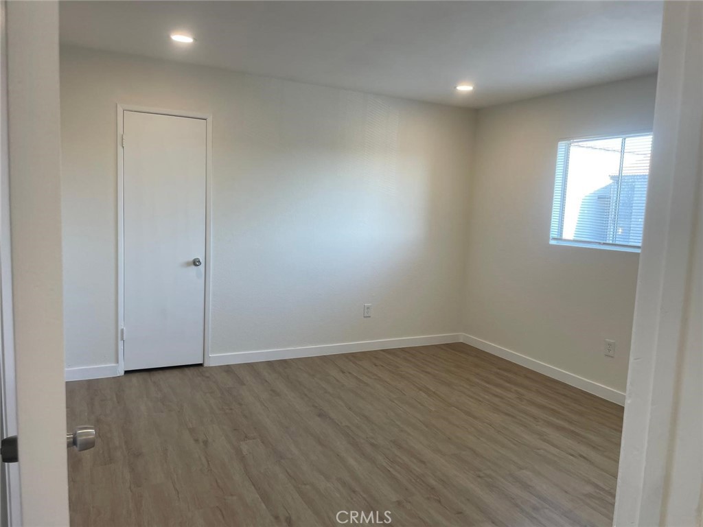 8135 Reseda Boulevard, Unit 9 Reseda, CA 91335 - Photo 6 of 8 an empty room with wooden floor and windows