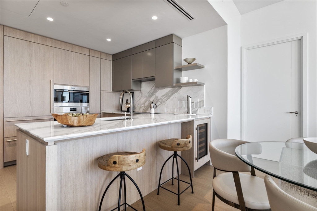 682 Atlantic Avenue, Unit 37D Boston, MA 02111 - Photo 8 of 42 a kitchen with stainless steel appliances a table and chairs in it