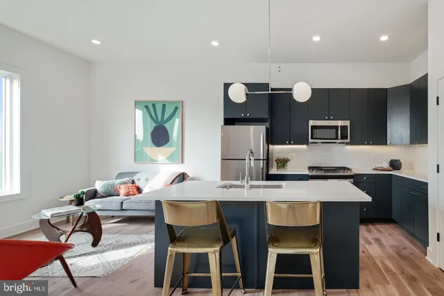 a kitchen with a dining table cabinets and stainless steel appliances