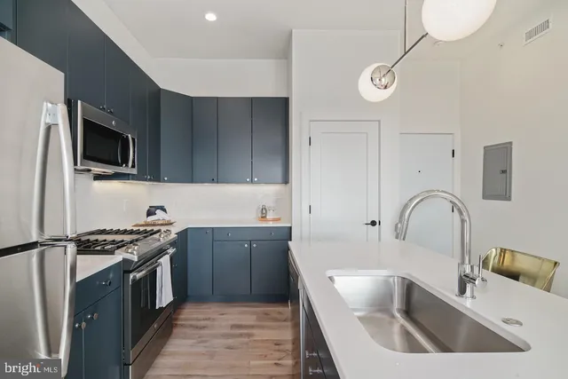 a kitchen with granite countertop a sink stainless steel appliances and cabinets