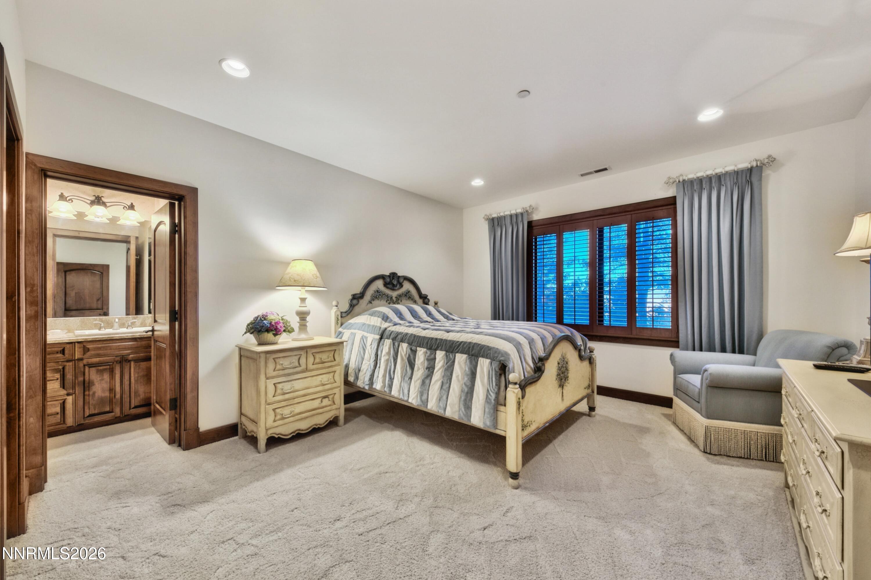 229 Five Creek Road Gardnerville, NV 89460 - Photo 26 of 50 a spacious bedroom with a bed and a chandelier