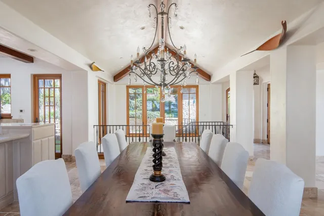 a living room with furniture a large window and a chandelier