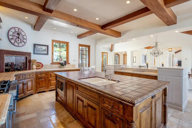 a kitchen with stainless steel appliances granite countertop a kitchen island a stove and a sink