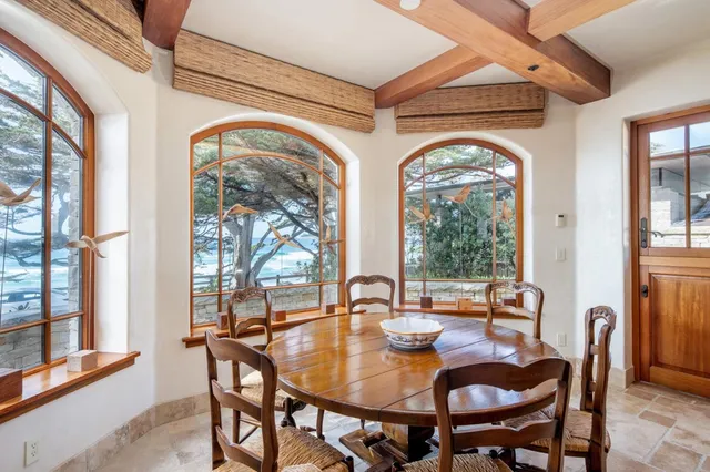 a view of a dining room with furniture large windows and wooden floor