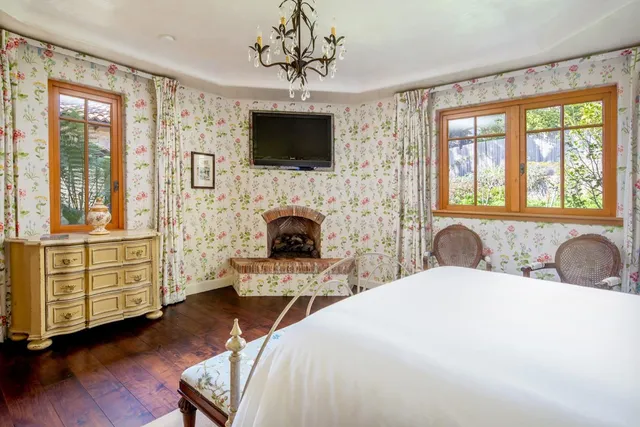 a spacious bedroom with a bed and a flat screen tv