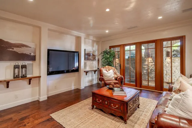 a living room with furniture a flat screen tv and a floor to ceiling window