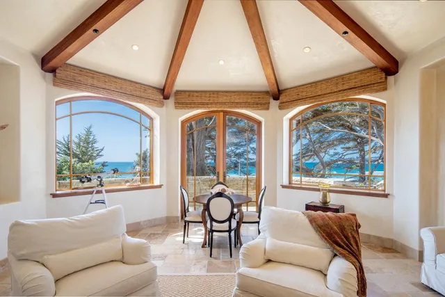a living room with furniture a fireplace and a large window