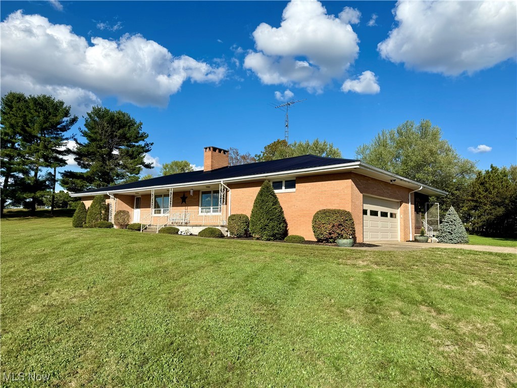 248 Scio Road Carrollton, OH 44615 - Photo 17 of 33 View of side of property featuring a yard, a chimney, brick siding, and a porch