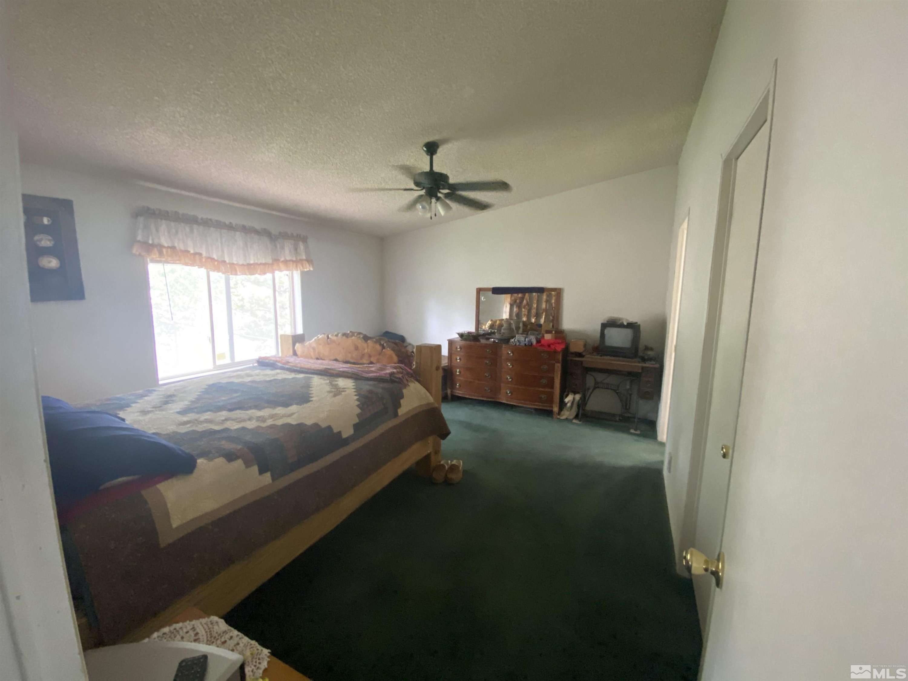 451 Manley Ranch Road Round Mountain, NV 89045 - Photo 14 of 40 a bed room with a bed and a chair