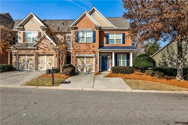 a view of a white house with a yard and large tree