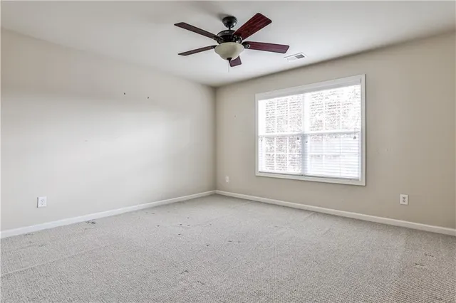 an empty room with a window and a ceiling fan