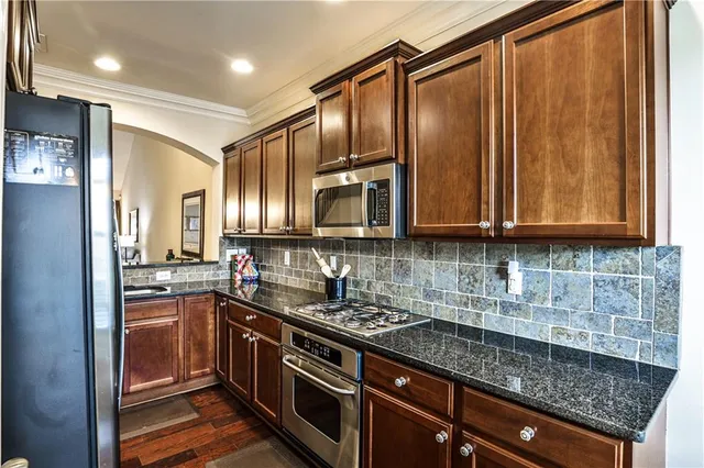 a kitchen with stainless steel appliances granite countertop a sink stove and refrigerator