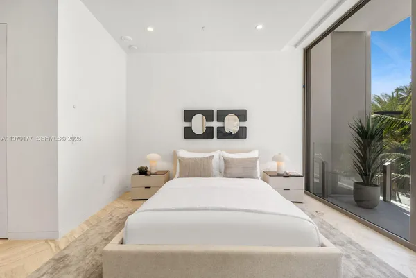 a bedroom with a large bed and a potted plant